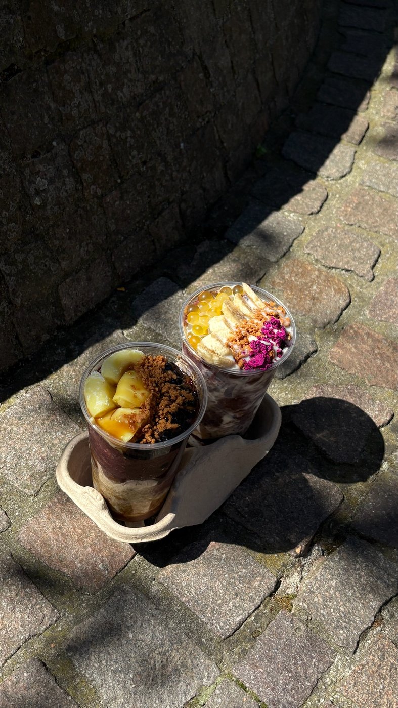 zwei tea99 açaí bowls to-go im kartonträger auf darmstädter kopfsteinpflaster